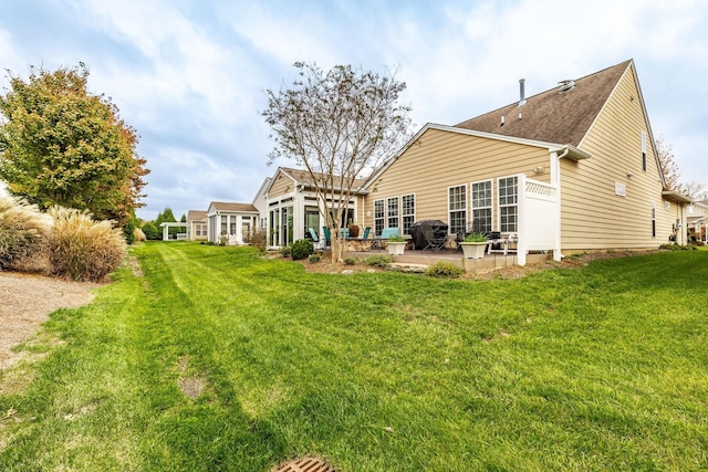 back of property with a patio area and a yard