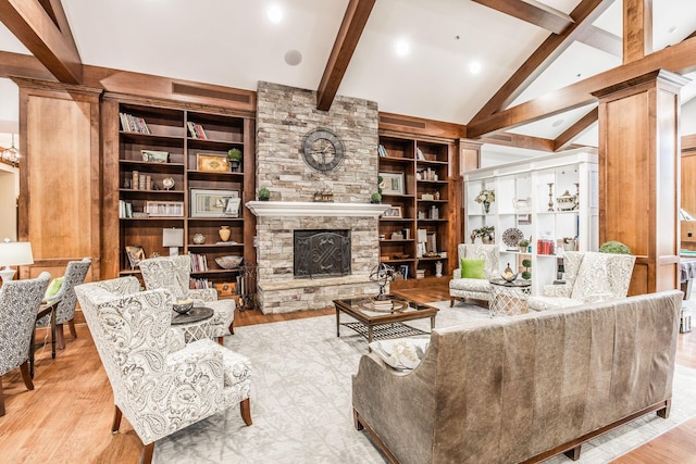 living room with a fireplace, vaulted ceiling with beams, light hardwood / wood-style flooring, and built in features