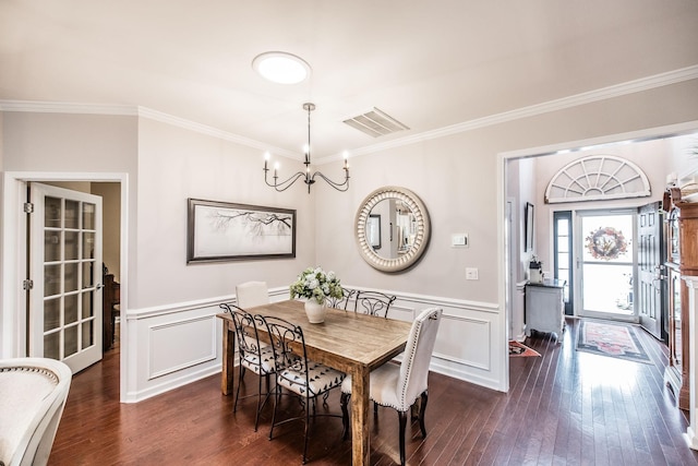 dining space featuring dark wood-type flooring, a notable chandelier, and ornamental molding