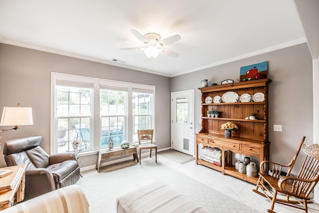 sitting room with ceiling fan, light tile patterned floors, and crown molding