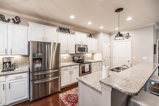 kitchen featuring white cabinets, stainless steel appliances, and an island with sink