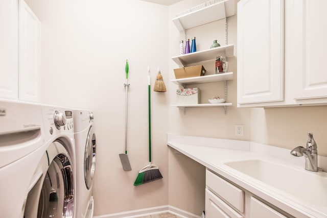 washroom with cabinets, sink, and washing machine and dryer