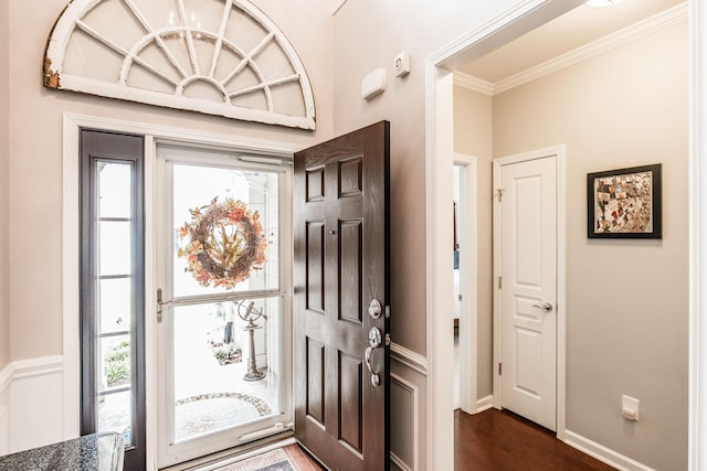 entrance foyer with crown molding and dark hardwood / wood-style flooring