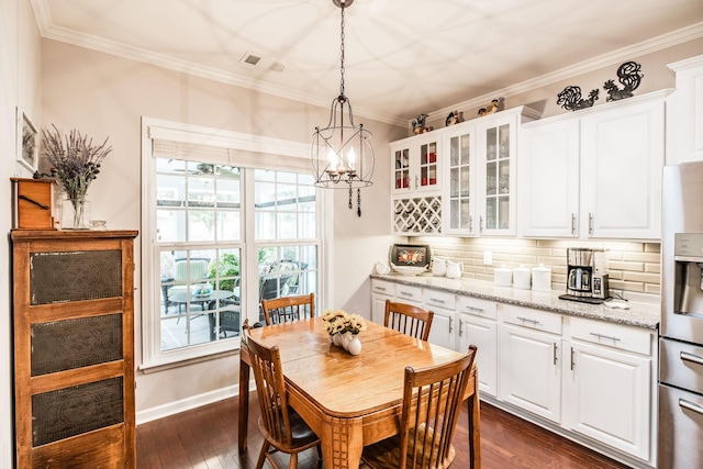 dining area with a chandelier, dark hardwood / wood-style flooring, and ornamental molding