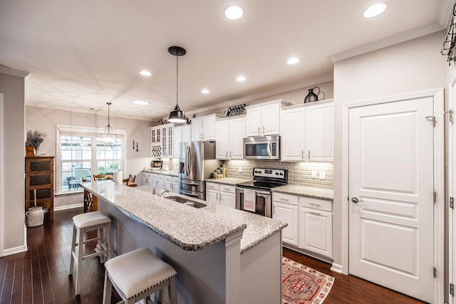 kitchen with white cabinets, appliances with stainless steel finishes, light stone countertops, and sink