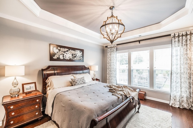 bedroom with a raised ceiling, crown molding, a chandelier, and dark hardwood / wood-style floors