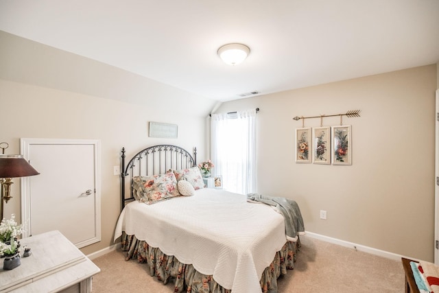 bedroom with light colored carpet and lofted ceiling