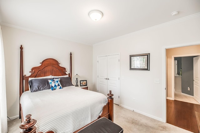 carpeted bedroom with crown molding and a closet