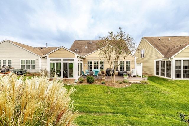 rear view of property featuring a lawn and a patio area