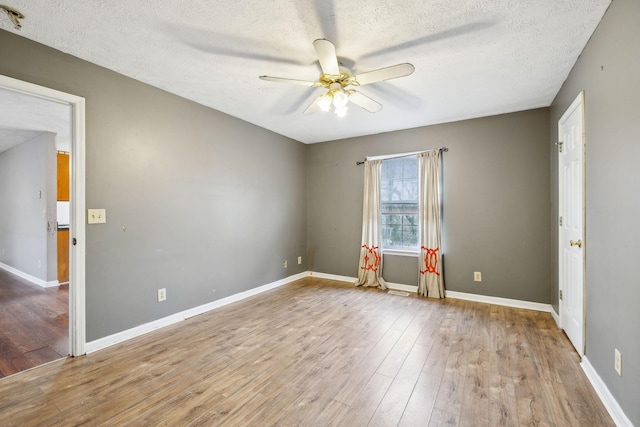 empty room featuring ceiling fan, light wood-type flooring, and a textured ceiling