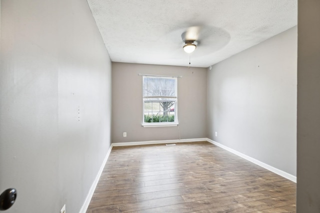 spare room with wood-type flooring, a textured ceiling, and ceiling fan