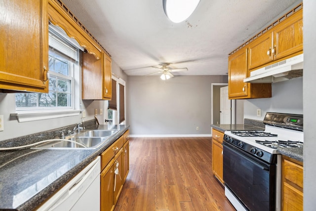 kitchen featuring ceiling fan, sink, dark hardwood / wood-style floors, and white appliances