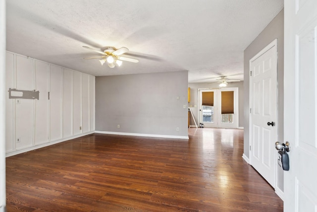 unfurnished room with ceiling fan, dark wood-type flooring, and a textured ceiling