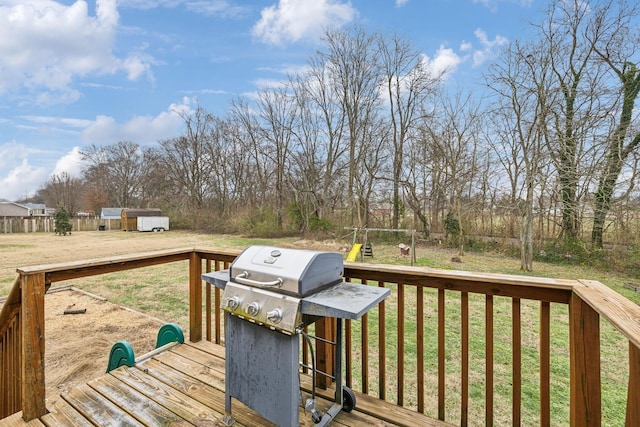 wooden deck with a playground, area for grilling, and a lawn