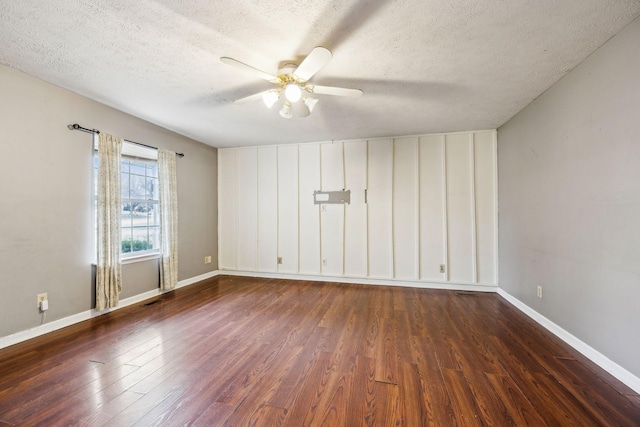 empty room featuring a textured ceiling, dark hardwood / wood-style flooring, and ceiling fan