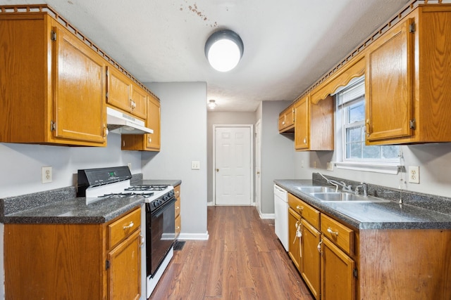 kitchen with dark hardwood / wood-style flooring, white appliances, and sink