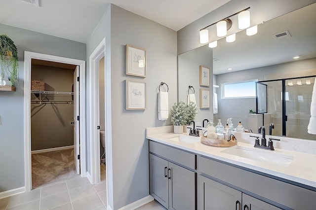 bathroom with tile patterned flooring, vanity, a shower with shower door, and toilet