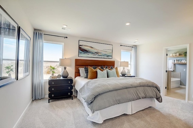 bedroom featuring ensuite bath and light carpet