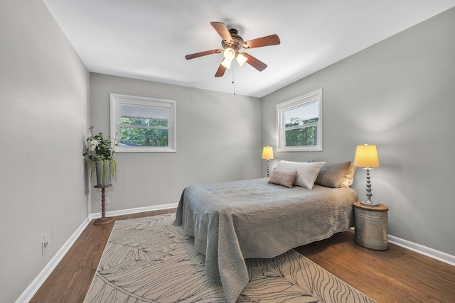 bedroom with multiple windows, hardwood / wood-style floors, and ceiling fan