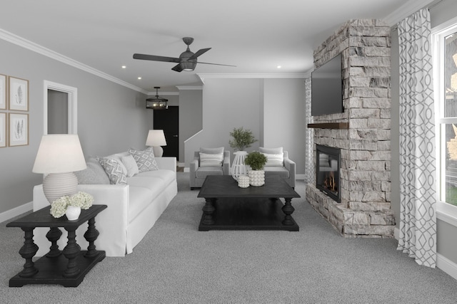 carpeted living room with ceiling fan, a stone fireplace, and crown molding