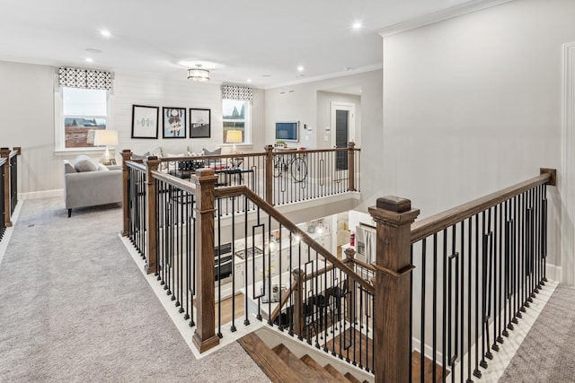 staircase with carpet floors and ornamental molding