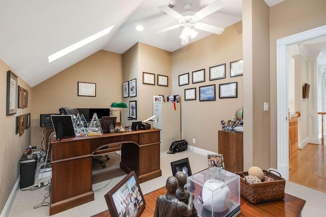 office area with ceiling fan, lofted ceiling with skylight, and light hardwood / wood-style floors