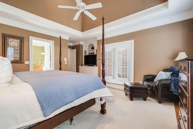 carpeted bedroom with a raised ceiling, ornamental molding, ensuite bathroom, and ceiling fan