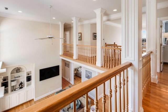 hall with light wood-type flooring, crown molding, and built in features