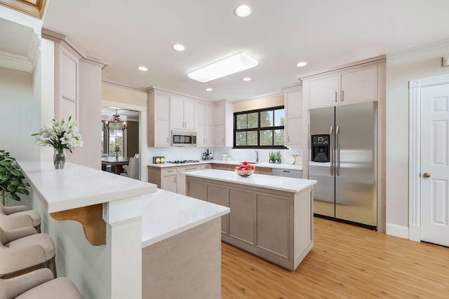 kitchen featuring stainless steel appliances, a kitchen bar, a healthy amount of sunlight, and kitchen peninsula