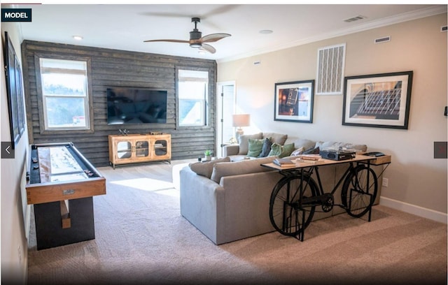 living room featuring plenty of natural light, ceiling fan, crown molding, and light carpet