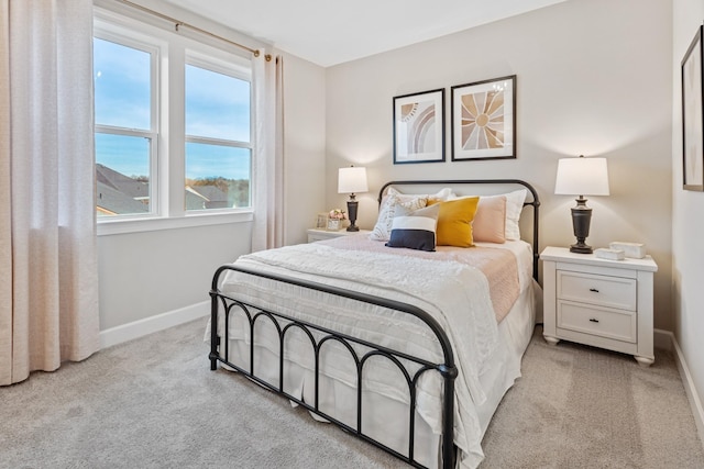 bedroom with light colored carpet and multiple windows