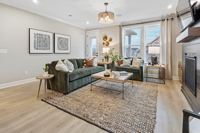 living room with a chandelier, light hardwood / wood-style floors, and ornamental molding