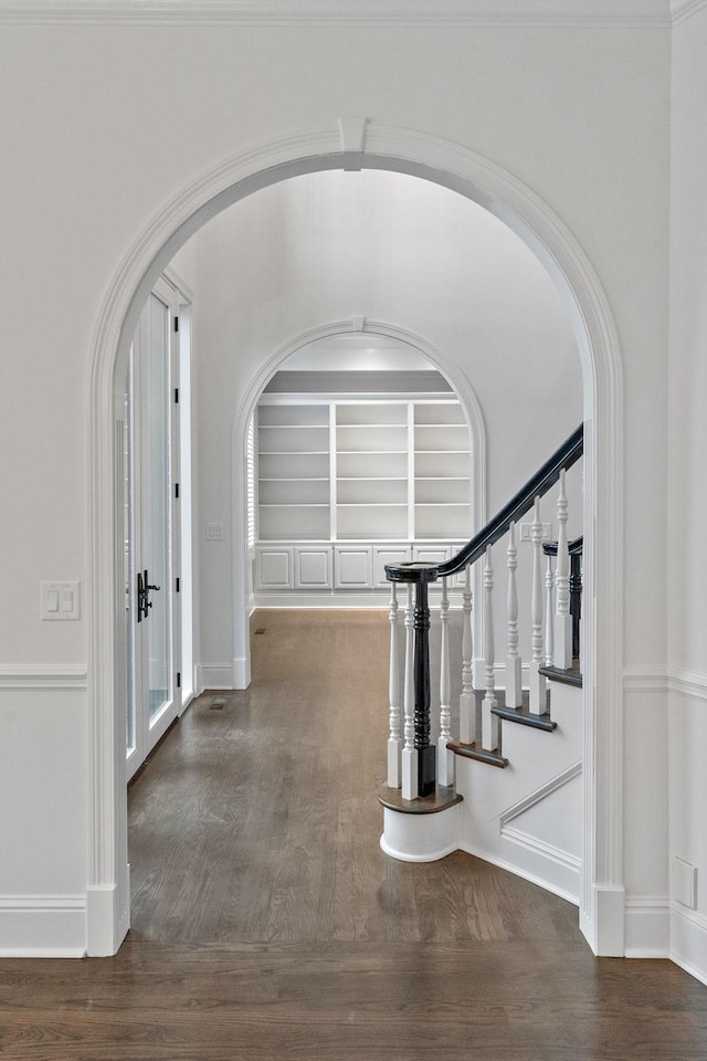 hallway with dark hardwood / wood-style floors and built in shelves