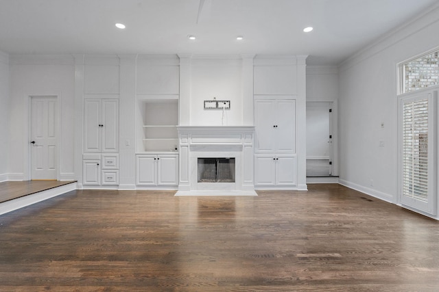 unfurnished living room with built in features, dark wood-type flooring, and ornamental molding