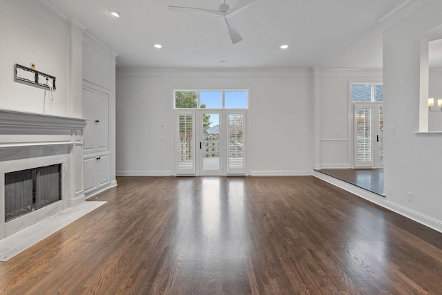 unfurnished living room featuring a fireplace, dark hardwood / wood-style floors, ceiling fan, and ornamental molding