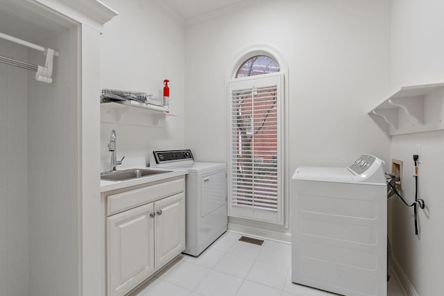 laundry room with light tile patterned floors, separate washer and dryer, crown molding, and sink