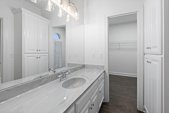 bathroom with vanity, wood-type flooring, and crown molding