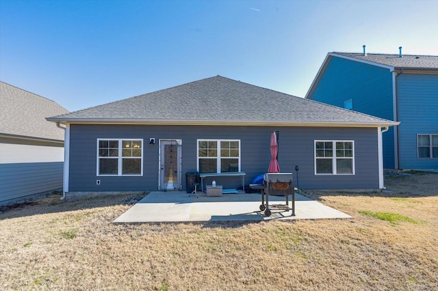 rear view of property with a lawn and a patio