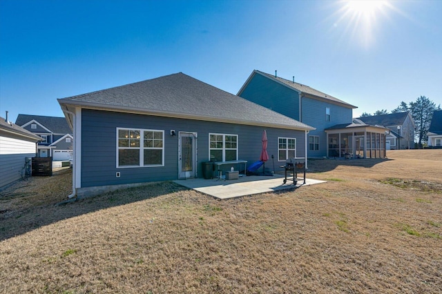 rear view of house with a yard, a patio, and a sunroom