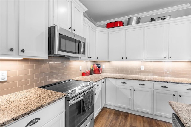 kitchen featuring backsplash, light stone counters, stainless steel appliances, crown molding, and white cabinetry