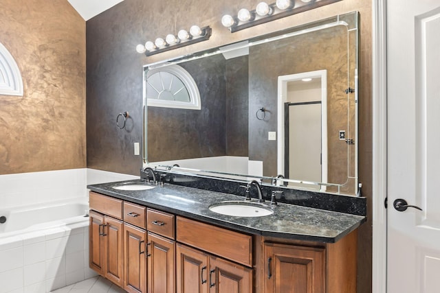 bathroom featuring vanity, tiled bath, and tile patterned flooring