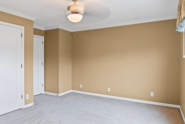 carpeted empty room featuring ornamental molding and ceiling fan