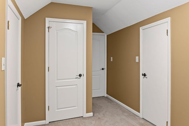 interior space featuring lofted ceiling, light carpet, and a textured ceiling