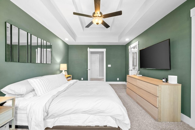 bedroom with carpet flooring, ceiling fan, and a tray ceiling