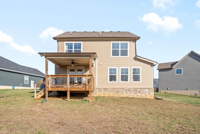 back of property with ceiling fan, a lawn, and a wooden deck