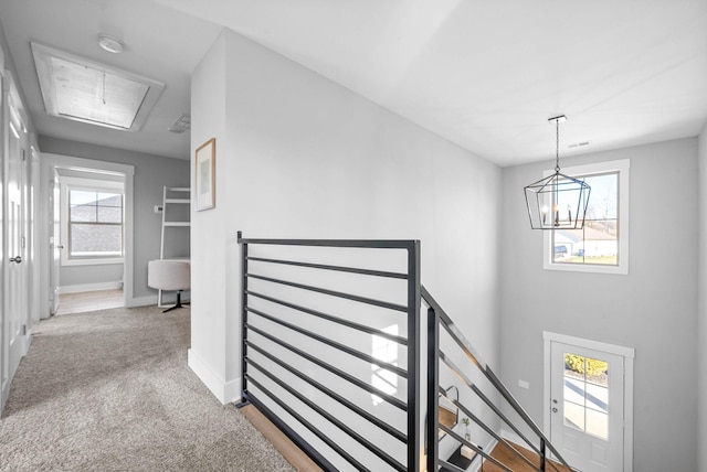 stairway featuring carpet flooring, an inviting chandelier, and a wealth of natural light