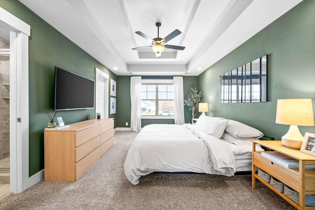 bedroom with a tray ceiling, ceiling fan, and carpet flooring