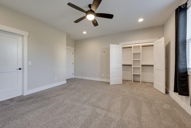 unfurnished bedroom featuring multiple windows, light colored carpet, and ceiling fan