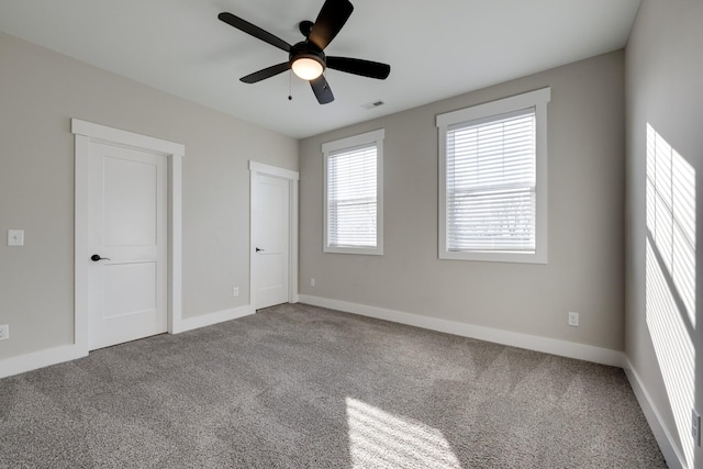 unfurnished room featuring ceiling fan and carpet floors