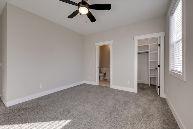 unfurnished bedroom featuring ensuite bath, ceiling fan, a spacious closet, light carpet, and a closet